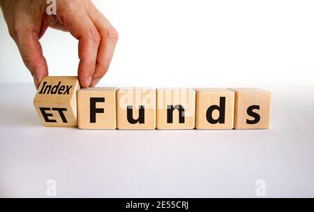 Fonds indiciels vs symbole ETF. Homme d'affaires transforme un cube et change les mots « ETF » en « Index funds ». Magnifique arrière-plan blanc, espace de copie. Business et ETF Banque D'Images