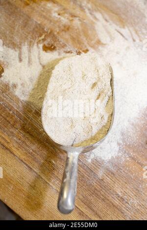 Farine de blé sur une table en bois et une cuillère de mesure. Banque D'Images