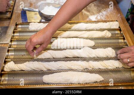 Processus de cuisson du pain. Femme travaillant avec de la pâte. Formant une baguette - French roll Banque D'Images