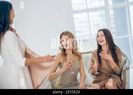 Trois belles filles choisissant une robe et regardant excité Banque D'Images