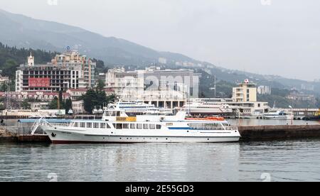 Yalta, Crimée - 8 mai 2018 : vue côtière du port de Yalta. Le bateau à passagers est amarré au quai. Les gens ordinaires sont sur la côte Banque D'Images