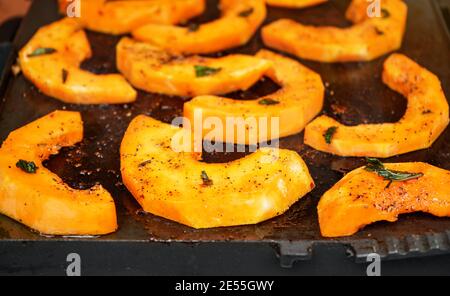 Morceaux de courge de noyer cendré orange vif avec épices grillées sur électrique gril Banque D'Images