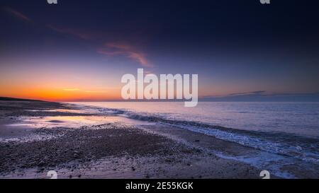 Coucher du soleil sur une plage déserte. Banque D'Images