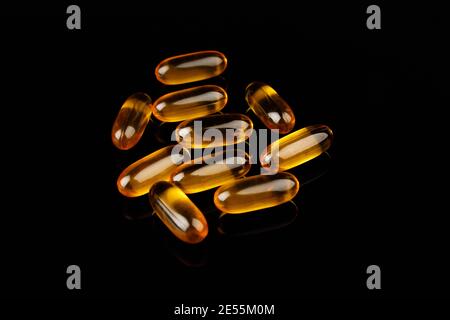 Capsules Omega-3 sur fond noir. Concept de santé avec capsules d'huile de poisson. Banque D'Images