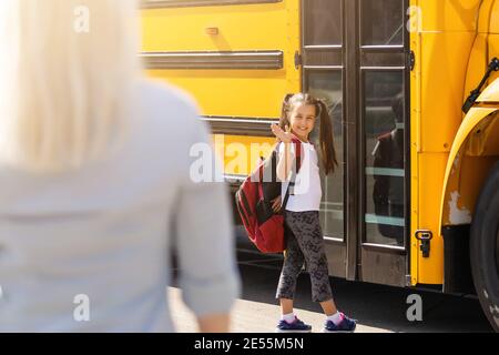 Belle petite fille avec la mère près de l'école Banque D'Images