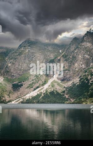 Tempête nuageux au-dessus du lac Morskie Oko reflétée dans l'eau. Montagnes Tatra, Pologne Banque D'Images