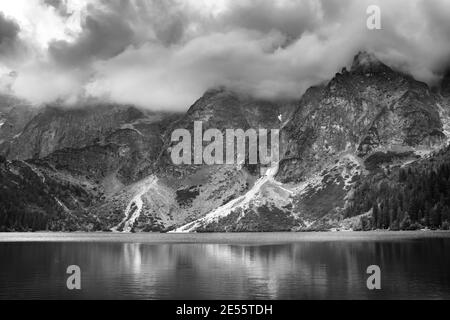 Tempête noire et blanche nuageux au-dessus du lac Morskie Oko, reflétée dans l'eau. Montagnes Tatra, Pologne Banque D'Images