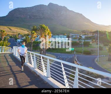 Nelson Mandela Boulevard- Cape Town, Afrique du Sud - 25-01-2021 Femme en masque bleu jogging sur le pont du Nelson Mandela Boulevard. Banque D'Images