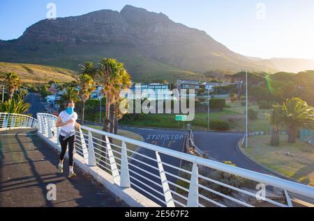 Nelson Mandela Boulevard- Cape Town, Afrique du Sud - 25-01-2021 Femme en masque bleu jogging sur le pont du Nelson Mandela Boulevard. Banque D'Images