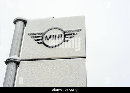 Le logo BMW Mini est couvert dans la neige annonçant la concession principale Et siège du constructeur automobile allemand en hiver isolé sur blanc Banque D'Images