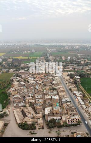 Vol en montgolfière au-dessus de Thèbes, vue sur les maisons et les terres agricoles égyptiennes, le Nil à l'arrière Banque D'Images