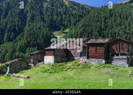 Un groupe de maisons traditionnelles en bois sombre constitue le village de Zmutt. Banque D'Images