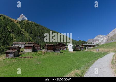 Un groupe de maisons traditionnelles en bois sombre constitue le village de Zmutt en dessous du Cervin. Banque D'Images