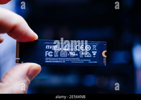 Londres, Royaume-Uni - 18 janvier 2019: POV Personal perspective main mâle tient le nouveau connecteur M2 le nouveau Samsung NVME V-NAND SSD Samsung 970 disque avec un espace de stockage de téraoctets - fond bleu et la signalisation produit de Chine Banque D'Images