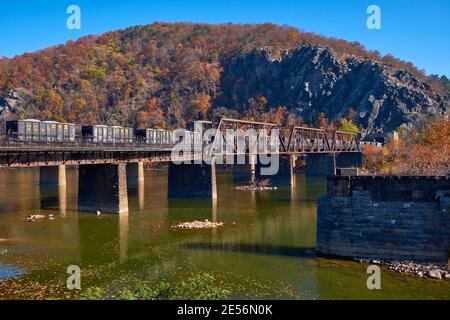 Vue d'automne d'un train CSX avec wagons-trémies traversant le pont de chemin de fer Winchester et Potomac. À Harpers Ferry, Virginie-Occidentale. Banque D'Images