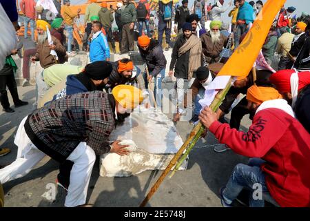 Des manifestants délèvent des barricades en béton pendant la manifestation.des milliers d'agriculteurs du Punjab et de l'État de Haryana continuent de protester contre les nouvelles lois du gouvernement central sur les trois produits agricoles. La police de Delhi a autorisé les agriculteurs à protester contre une parade de tracteur d'environ 62 km le jour de la République et le début de la parade depuis les frontières de Singhu, Tikri et Ghazpur. Banque D'Images