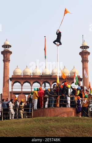 Un manifestant monte un mât au fort Rouge pendant la manifestation.des milliers d'agriculteurs du Punjab et de l'État de Haryana continuent de protester contre les nouvelles lois du gouvernement central en matière d'agriculture. La police de Delhi a autorisé les agriculteurs à protester contre une parade de tracteur d'environ 62 km le jour de la République et le début de la parade depuis les frontières de Singhu, Tikri et Ghazpur. Banque D'Images