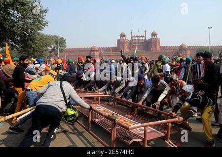 Des manifestants délèvent des barricades de police au fort Rouge pendant la manifestation.des milliers d'agriculteurs du Punjab et de l'État de Haryana continuent de protester contre les nouvelles lois du gouvernement central sur l'agriculture. La police de Delhi a autorisé les agriculteurs à protester contre une parade de tracteur d'environ 62 km le jour de la République et le début de la parade depuis les frontières de Singhu, Tikri et Ghazpur. Banque D'Images