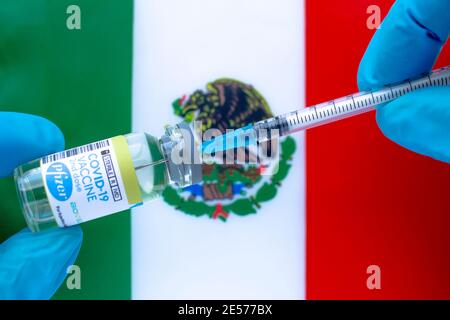 Calgary (Alberta). Canada. 20 janvier 2021. Un travailleur de la santé avec un vaccin Pfizer et une seringue avec un drapeau mexicain sur le fond Banque D'Images