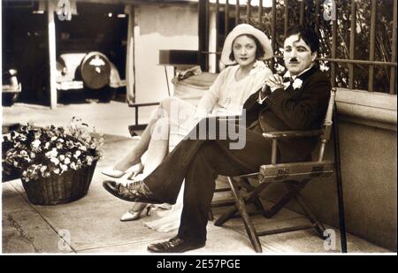 1930 , Hollywood , États-Unis : L'actrice allemande MARLENE DIETRICH ( 1901 - 1992 ) vient d'arriver aux Etats-Unis d'Allemagne rencontrez le célèbre acteur et réalisateur anglais CHARLES CHAPLIN ( 1889 - 1977 ) lors de la fabrication de LUMIÈRES DE la VILLE de cinéma ( Luci della città - 1931 ). Ces deux légendes de film ne se sont jamais jouées ensemble dans le même film . - CINÉMA - FILM - Candid - portrait - ritratto - chapeau - cappello - robe blanche - abito bianco - regista camografico - attore - atrice - rosa - fleur - fleurs - fiore all' occhiello - fiori - mazzo di rose - comico - gambe - jambes - papillon - cravate - Banque D'Images