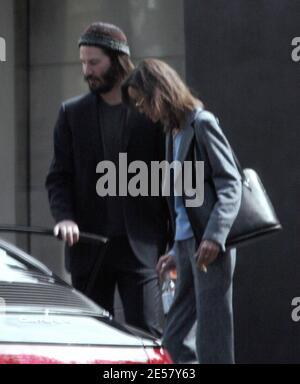 Exclusif !! Un regard triste Keanu Reeves ouvre la porte d'une voiture pour une femme compagnon après une visite de sa maison de Hollywood Hills à CA. L'acteur a montré à la femme en train de regarder les rénovations qu'il a fait à sa maison de style moderne depuis plusieurs mois. 3/4/07 [[ral]] Banque D'Images