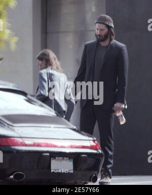 Exclusif !! Un regard triste Keanu Reeves ouvre la porte d'une voiture pour une femme compagnon après une visite de sa maison de Hollywood Hills à CA. L'acteur a montré à la femme en train de regarder les rénovations qu'il a fait à sa maison de style moderne depuis plusieurs mois. 3/4/07 [[ral]] Banque D'Images