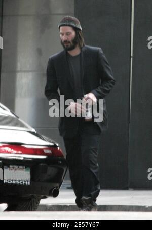 Exclusif !! Un regard triste Keanu Reeves ouvre la porte d'une voiture pour une femme compagnon après une visite de sa maison de Hollywood Hills à CA. L'acteur a montré à la femme en train de regarder les rénovations qu'il a fait à sa maison de style moderne depuis plusieurs mois. 3/4/07 [[ral]] Banque D'Images