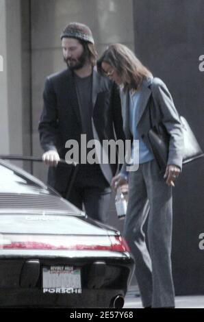 Exclusif !! Un regard triste Keanu Reeves ouvre la porte d'une voiture pour une femme compagnon après une visite de sa maison de Hollywood Hills à CA. L'acteur a montré à la femme en train de regarder les rénovations qu'il a fait à sa maison de style moderne depuis plusieurs mois. 3/4/07 [[ral]] Banque D'Images