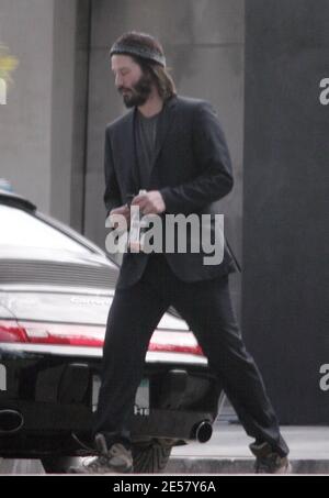 Exclusif !! Un regard triste Keanu Reeves ouvre la porte d'une voiture pour une femme compagnon après une visite de sa maison de Hollywood Hills à CA. L'acteur a montré à la femme en train de regarder les rénovations qu'il a fait à sa maison de style moderne depuis plusieurs mois. 3/4/07 [[ral]] Banque D'Images