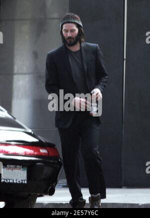 Exclusif !! Un regard triste Keanu Reeves ouvre la porte d'une voiture pour une femme compagnon après une visite de sa maison de Hollywood Hills à CA. L'acteur a montré à la femme en train de regarder les rénovations qu'il a fait à sa maison de style moderne depuis plusieurs mois. 3/4/07 [[ral]] Banque D'Images