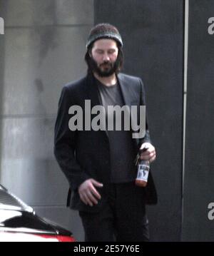 Exclusif !! Un regard triste Keanu Reeves ouvre la porte d'une voiture pour une femme compagnon après une visite de sa maison de Hollywood Hills à CA. L'acteur a montré à la femme en train de regarder les rénovations qu'il a fait à sa maison de style moderne depuis plusieurs mois. 3/4/07 [[ral]] Banque D'Images