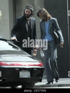 Exclusif !! Un regard triste Keanu Reeves ouvre la porte d'une voiture pour une femme compagnon après une visite de sa maison de Hollywood Hills à CA. L'acteur a montré à la femme en train de regarder les rénovations qu'il a fait à sa maison de style moderne depuis plusieurs mois. 3/4/07 [[ral]] Banque D'Images