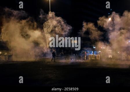 Tripoli, Liban, 26 janvier 2021. Un homme marche à travers le gaz lacrymogène tandis que les citoyens de la ville la plus pauvre du Liban descendent dans la rue pendant ce qui a été appelé le plus dur confinement au monde. Un couvre-feu de 24 heures avec la plupart des industries et presque tous les magasins de détail, y compris les magasins d'alimentation fermés par des restrictions de pandémie jusqu'au 8 février, signifie que les travailleurs de jour ne peuvent pas travailler. Les laisser dans l'incapacité de se permettre de nourrir leurs familles pendant la période de 25 jours, car le verrouillage rapide est venu sans le soutien du gouvernement. Elizabeth FITT crédit: Elizabeth FITT/Alay Live News Banque D'Images