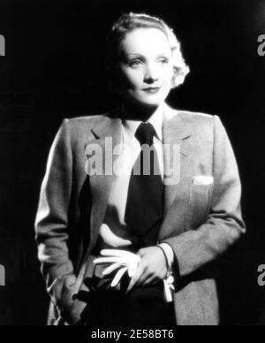 1936. : l'actrice MARLENE DIETRICH ( 1902 - 1992 ) , Pubblicty Paramount Images pour le film DÉSIR de Frank Borzage - CINÉMA - FILM - atrice - portrait - ritratto - guanto - guanti - gant - gants - bionda - cheveux blonds - capelli biondi - blondie - femme habillée comme un homme - personnage masculin - donna vestita Travestita da uomo con abbigliamento maschile - cravatta - cravate - collier - colletto pochette - fazzoletto nel taschino --- Archivio GBB Banque D'Images