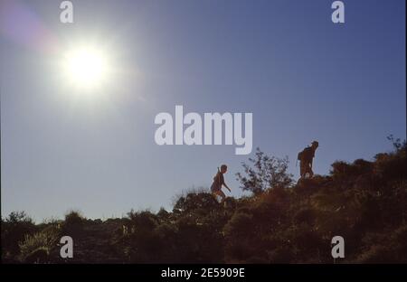 Deux personnes âgées qui font de la randonnée jusqu'à Fortynine Palms Oasis dans le Joshua de Californie Parc national Tree Banque D'Images