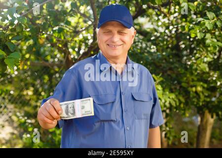 Un homme âgé qui détient une pile d'argent Banque D'Images