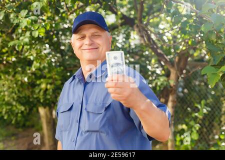Un homme âgé qui détient une pile d'argent Banque D'Images