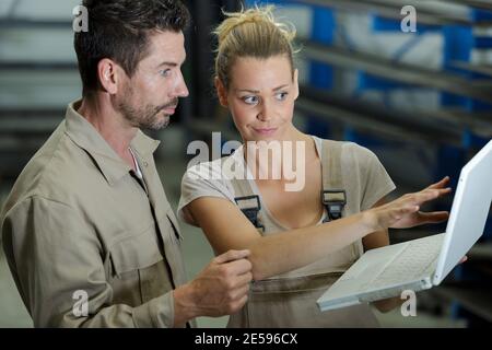 techniciens utilisant des ordinateurs qui surplombent les cuves Banque D'Images