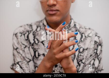 Portrait d'un jeune homme avec vernis à ongles bleu Banque D'Images