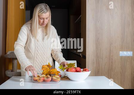 femme dans un récipient en verre prépare des pommes pour la cuisson, fait maison desert baking concept Banque D'Images