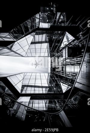 Avion de transport de passagers géant volant au-dessus de verre d'architecture moderne Miroir gratte-ciel bâtiment centre ville spectaculaire symétrique Londres Angleterre Banque D'Images