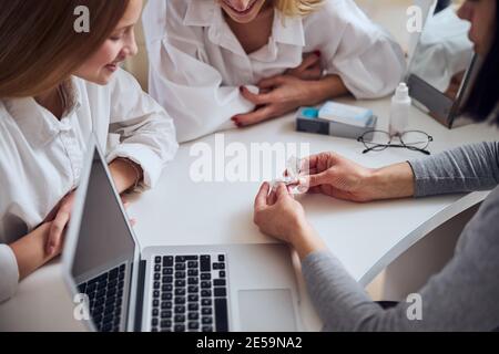 Médecin expérimenté démontrant de nouveaux outils pour une meilleure vision sans verre Banque D'Images
