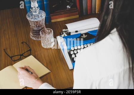 Photo d'époque de vieux livres. La main de l'écrivain est sur la machine à écrire .Writer écrivant un roman d'amour. Romancier écrivant un roman sur une machine à écrire Banque D'Images