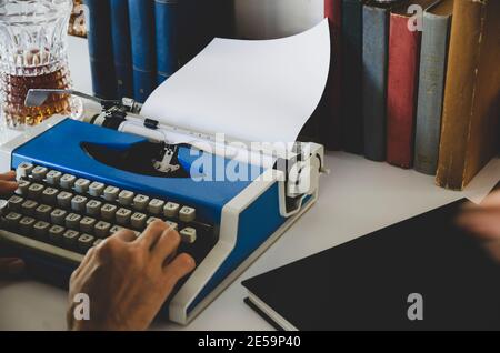 Photo d'époque de vieux livres. La main de l'écrivain est sur la machine à écrire .Writer écrivant un roman d'amour. Romancier écrivant un roman sur une machine à écrire Banque D'Images