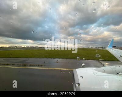 Le trajet en taxi à l'aéroport par mauvais temps, par temps pluvieux. Vue sur la fenêtre de l'avion sur le tarmac de la piste. Gouttes de pluie sur la fenêtre. Photo de haute qualité Banque D'Images