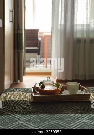 Plateau en bois avec plateau à thé et une tasse sur le lit. L'atmosphère de confort dans l'hôtel Banque D'Images