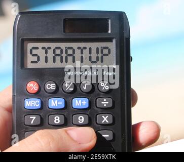Démarrage par mot sur l'écran de la calculatrice, paysage de plage. Nouveau concept d'entreprise Banque D'Images