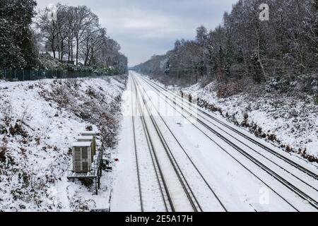 La ligne de chemin de fer entre Woking et Brookwood dans une coupe vue d'un pont au-dessus d'un jour de neige en hiver, Woking, Surrey, sud-est de l'Angleterre Banque D'Images