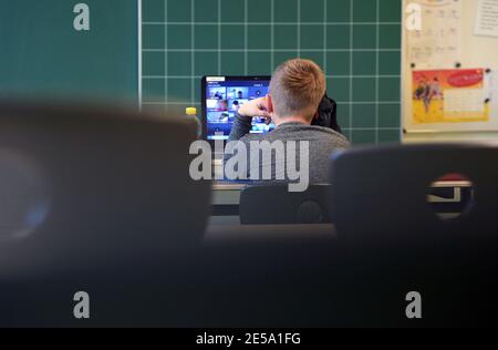 21 janvier 2021, Brandebourg, Oranienburg: Joel, âgé de neuf ans, de troisième année, est assis dans une salle de classe à l'école Comenius pendant une leçon d'école au portable devant un tableau noir sur la table. Il y a cinq ans, l'école primaire intégrative avec des groupes de soutien linguistique a déménagé dans un nouveau bâtiment à Oranienburg-Süd. Photo: Soeren Stache/dpa-Zentralbild/ZB Banque D'Images