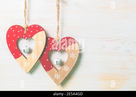 Deux décorations en bois coeur d'amour accrochées sur fond de bois peint blanc vintage. Concept de la Saint-Valentin. Copier l'espace Banque D'Images